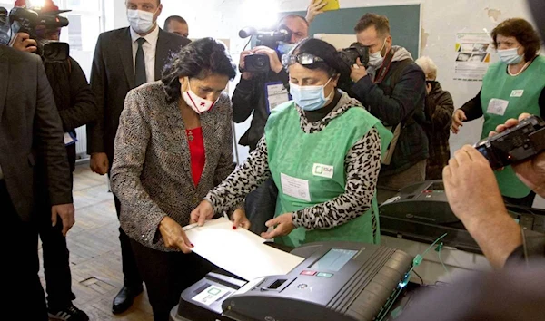 Georgia's President Salome Zurabishvili (center left) casts her ballot at a polling station during national municipal elections in Tbilisi, Georgia, October 2, 2021 | AP