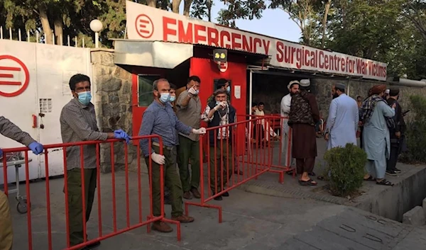 Medics stand at the entrance of a hospital as they wait to receive victims of an explosion in Kabul on October 3, 2021