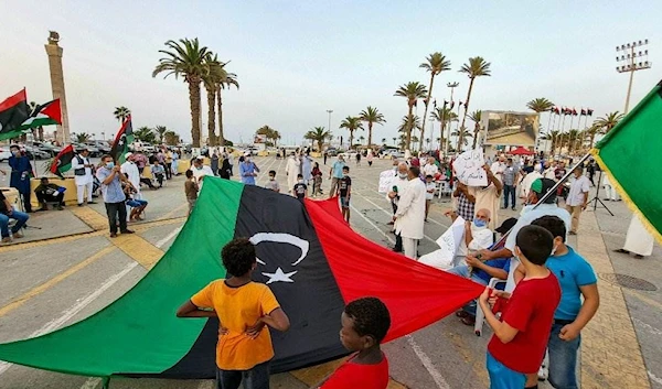 People gather with Libyan national flags at the Martyrs' Square in the center of Tripoli on August 20 | AFP