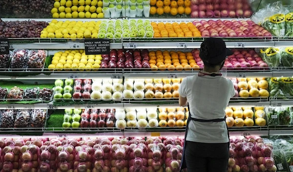 A sales assistant arranges fruit at the produce section in the supermarket at the SM City Bacoor shopping mall in Bacoor, the Philippines | Bloomberg