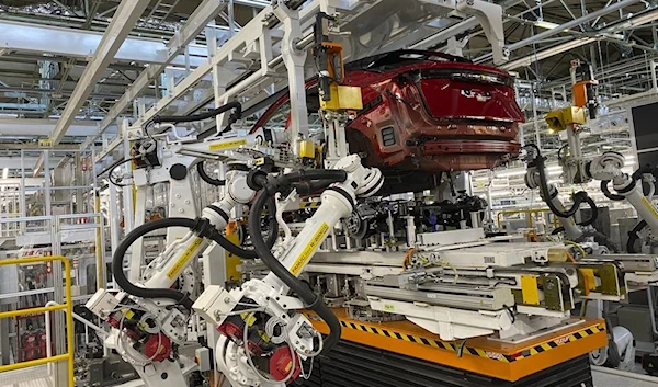 Robotic arms put in the electric vehicle powertrain into the Ariya model in the assembly line at Nissan's Tochigi plant.