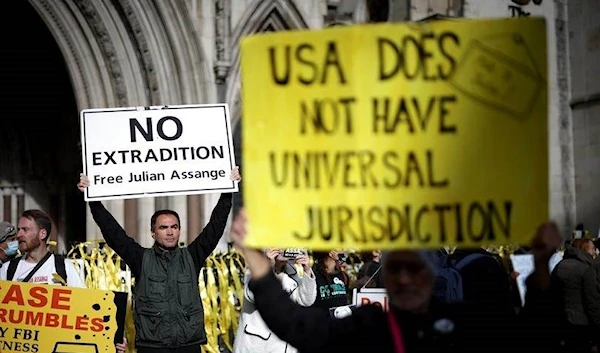 Outside the Royal Courts of Justice in London, supporters of Wikileaks founder Julian Assange hold banners during a protest (Source: Reuters)