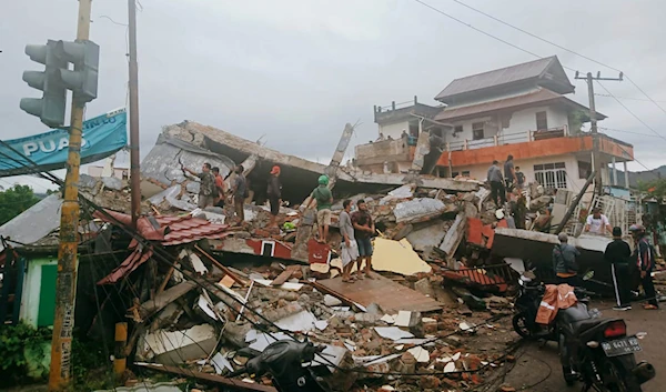 Residents inspect eartquake-damaged buildings in Mamuju, West Sulawesi, Indonesia, on January 15, 2021 (Credit: AP)