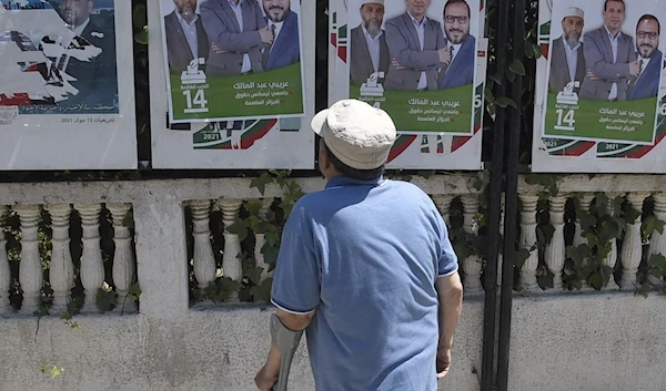 A man looks at election posters for candidates of the "Justice and Development Front" political party in Algeria (AFP).