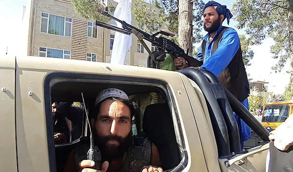 Taliban fighters in a vehicle along the roadside in Herat