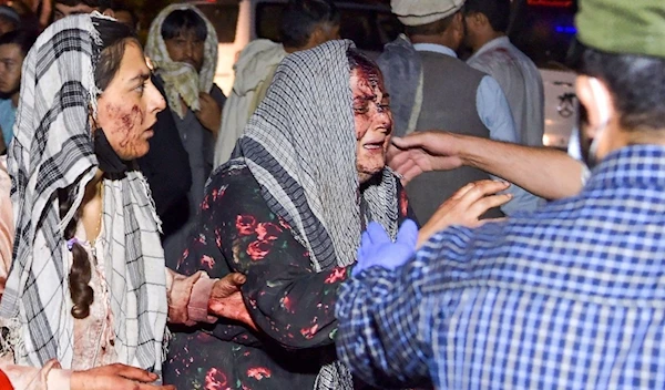 Wounded women arrive at a hospital for treatment after two blasts in Kabul on August 26, 2021 | AFP