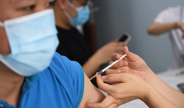 A man receives a dose of the AstraZeneca vaccine for the COVID-19 at the Bach Mai Hospital in Hanoi on May 17, 2021 | AFP