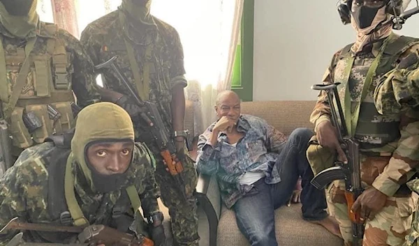 President of Guinea Alpha Conde surrounded in a room by army special forces