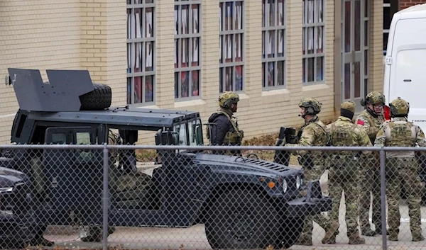 Law enforcement teams stage near Congregation Beth "Israel" while conducting SWAT operations.