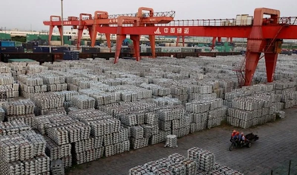 Workers ride on an motor rickshaw through an aluminium ingots depot in Wuxi, Jiangsu province in this September 26, 2012 file picture. REUTERS/