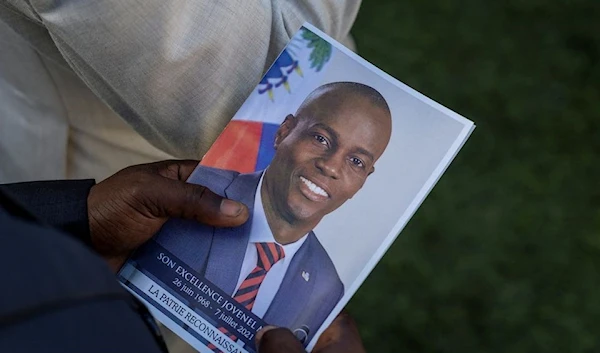 A person holds a photo of late Haitian President Jovenel Moise (Reuters)