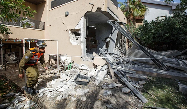 A soldier from the Israeli military's Home Front Command walks outside a house in Askalan following a Hamas attack on May 20, 2021