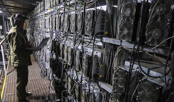 A maintenance specialist works inside the data center of the BTC KZ crypto mining company located near the coal-fired thermal power plant outside the town of Ekibastuz, Kazakhstan November 7, 2021 (REUTERS/Pavel Mikheyev)