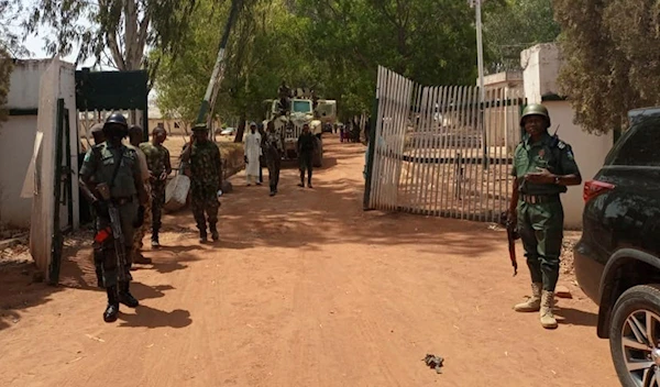 Nigerian soldiers and police officers stand at the entrance of the Federal College of Forestry Mechanisation in Mando, Kaduna state, on March 12, 2021 (AFP)