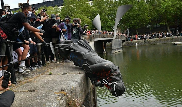 Protesters throw statue of slave trader Edward Colston into Bristol harbor, 2020. (Press Association)