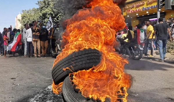 Sudanese protesters rallying against the military, walk past tyres set ablaze by fellow demonstrators in the capital Khartoum, on January 6, 2022. PHOTO/ AFP