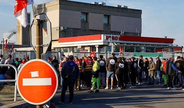 People gather during a TotalEnergies and Esso ExxonMobil workers' protest outside an Esso refinery (Reuters)