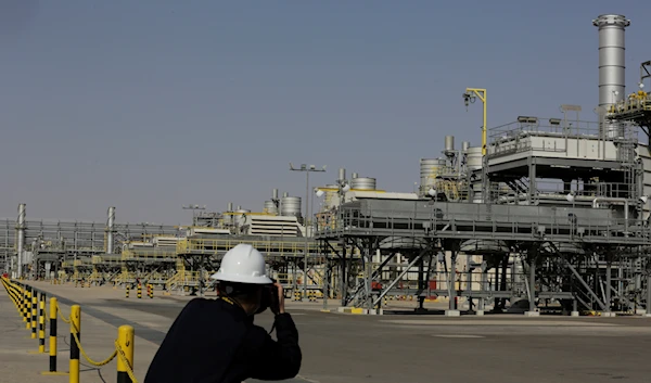 A photographer takes pictures of the Khurais oil field during a tour for journalists, 150 km east-northeast of Riyadh, Saudi Arabia, June 28, 2021 (AP Photo/Amr Nabil, File)