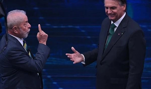 Former president Luiz Inacio Lula da Silva (L), and President Jair Bolsonaro (R) gesture during a televised debate (AFP)