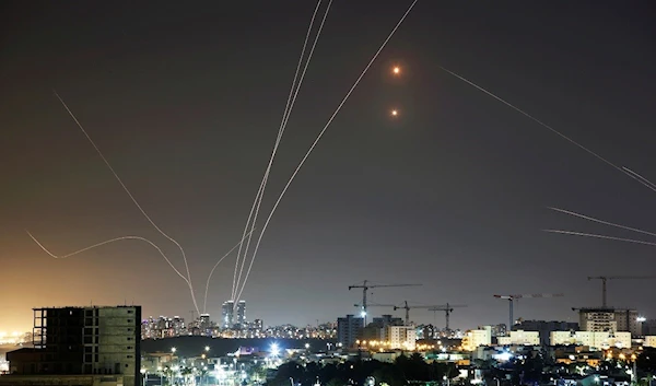 Streaks of light are seen as the Israeli occupation's Iron Dome intercepts rockets launched from the Gaza Strip toward "Israel" (Reuters)