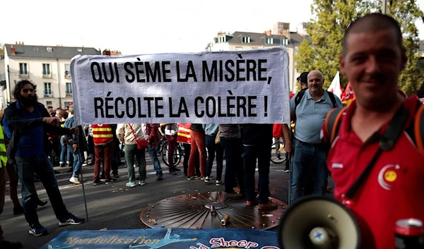 Protesters hold a banner that reads, "who sows misery reaps anger" during a demonstration, in Nantes, western France, Tuesday, Oct. 18, 2022 (AP Photo/Jeremias Gonzalez)