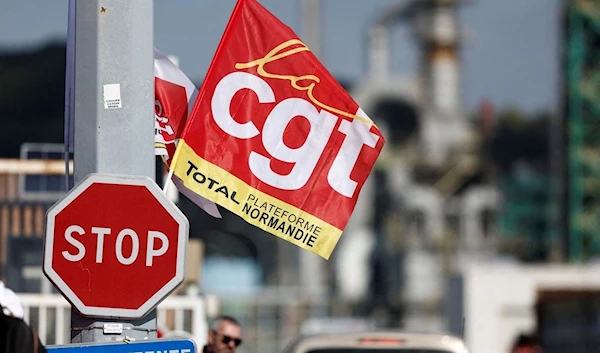 A flag of French CGT labour union flutters as workers on strike gather in front of the TotalEnergies oil refinery in France. (REUTERS)