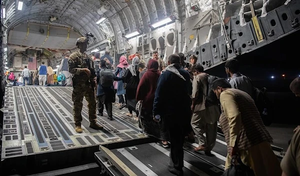 Afghan evacuees board a U.S. Air Force C-17 Globemaster III at the international airport in Kabul, Afghanistan, on Aug. 22, 2021. (Donald Allen/U.S. Central Comman).