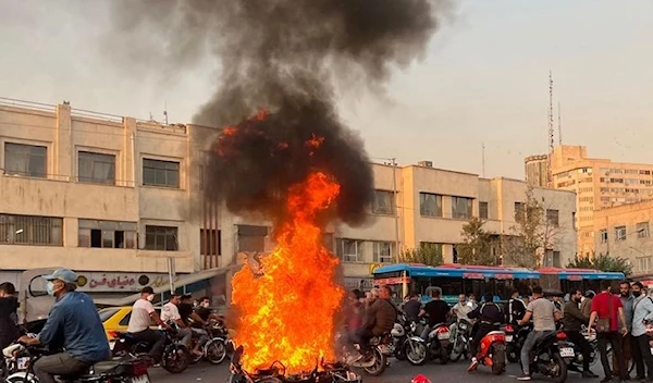 People gather next to burning a motorcycle in the Iranian capital Tehran on October 8, 2022(AFP)