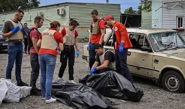 Medics check bodies after an attack on a civilian convoy near Zaporozhye on October 1 (AFP)