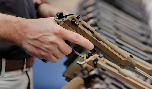 A man inspects a handgun. (REUTERS )