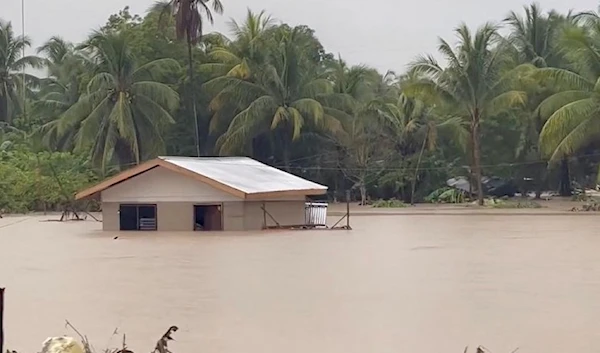 Flood waters surround a building following a heavy storm in Datu Odin Sinsuat, Maguindanao, Philippines (Reuters)