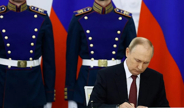 Russian President Vladimir Putin during the signature process (Reuters)