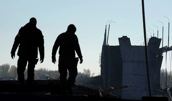 Ukrainian soldiers inspect damaged Antonovsky bridge over the Dnieper river in Kherson, Tuesday, Nov. 15, 2022. (AP Photo/Efrem Lukatsky)