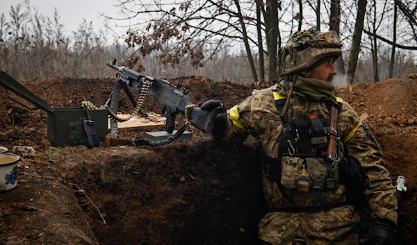 An Ukrainian soldier stands on duty with his machine gun at an undisclosed location in Donetsk region, Wednesday, Nov. 16, 2022 (AP Photo/Roman Chop)