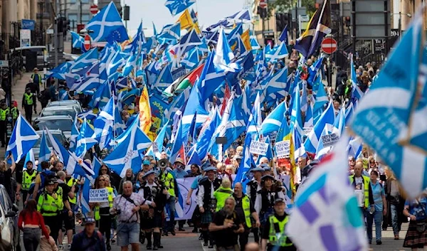 People take part in the All Under One Banner (AUOB) march for independence and protest against the privatisation of the NHS through the city of Glasgow, Scotland, 14 May 2022.