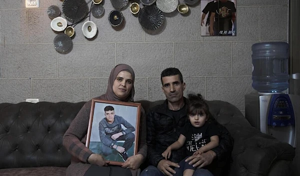 Ahmad’s family pose for a portrait with his sister, Sham, in their home in East Al-Quds, Nov. 8, 2022 (AP)