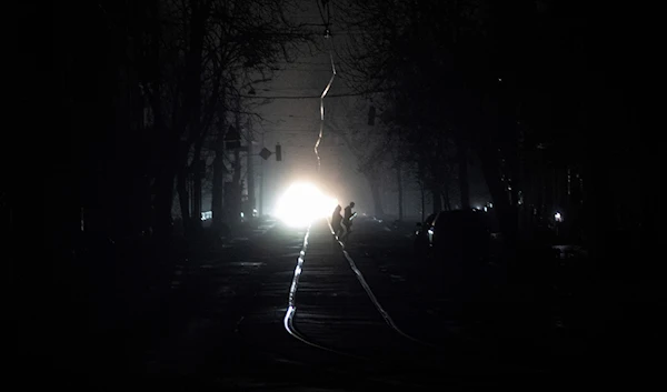 People cross the road at the city center which lost electrical power after a Russian rocket attack in Kiev, Ukraine, Thursday, Nov. 24, 2022 (AP Photo/Evgeniy Maloletka)