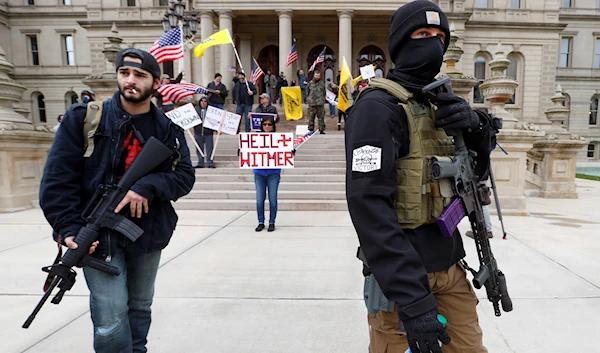 Protesters carrying rifles near the steps of the Michigan State Capitol building in Lansing April 15, 2020 (AP Photo)