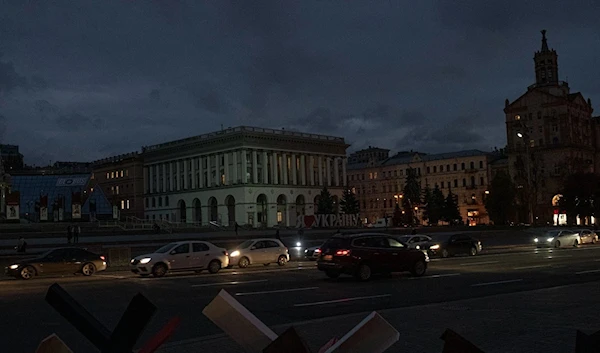 Cars pass in Independence Square at twilight in Kyiv, Ukraine, Monday, Oct. 31, 2022. (AP Photo/Andrew Kravchenko)