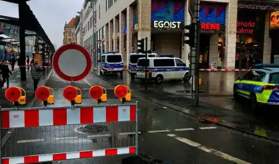 Police vehicles in the vicinity of closed off area at the Altmarktgalerie in Dresden (AP)