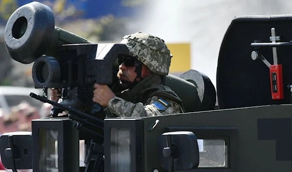 A Ukrainian serviceman rides atop of an APC with Javelin anti-tank missiles during a military parade in Kiev on August 24, 2018 (AFP)