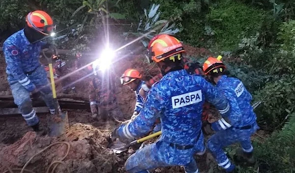 Malaysian rescuers attempting to save people from under the ruble (Twitter)