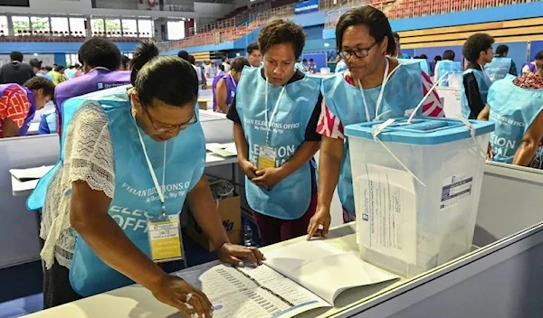 Election Commission officials prepare to open the ballot boxes for counting during Fiji’s general election in the capital city Suva on December 14, 2022 [Saeed Khan/AFP]