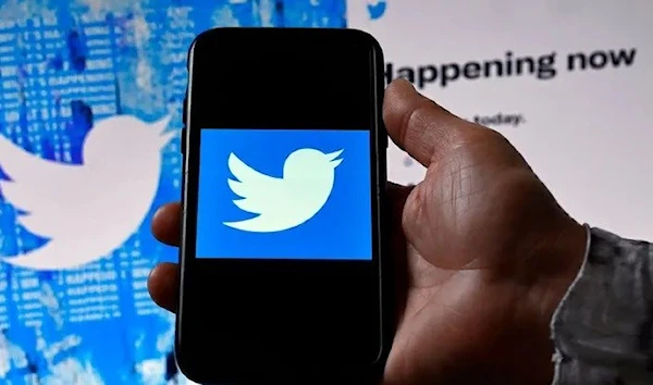 A phone screen displays the Twitter logo on a Twitter page background (AFP via Getty Images)