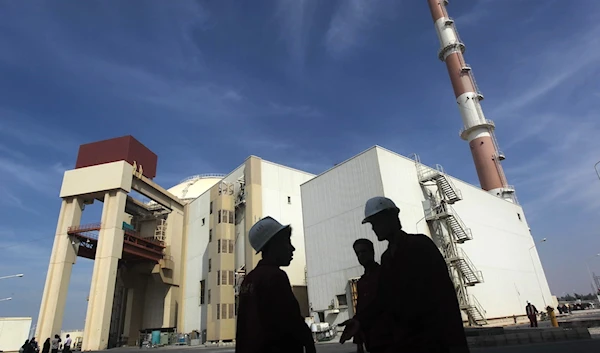 Iranian workers stand in front of the Bushehr nuclear power plant, October 26, 2010 (Reuters)