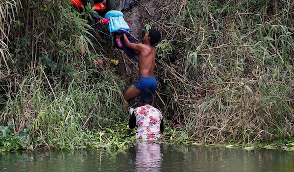 A migrant seeking asylum in the United States crossing the Rio Bravo River. (REUTERS)