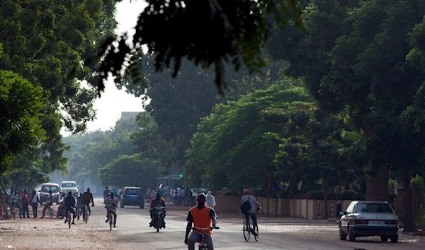 People ride bicycles and motorcycles on a street in Burkina Faso. (Reuters)