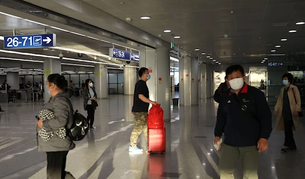 Travellers walk at the Beijing Capital International Airport in Beijing (REUTERS)