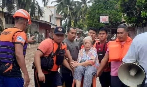 Rescue workers helps a resident affected by floods (REUTERS)