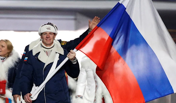 Alexander Zubkov of Russia carries the national flag as he leads the team during the opening ceremony of the 2014 Winter Olympics in Sochi, Russia on Feb. 7, 2014 (AP Photo/Mark Humphrey, File)